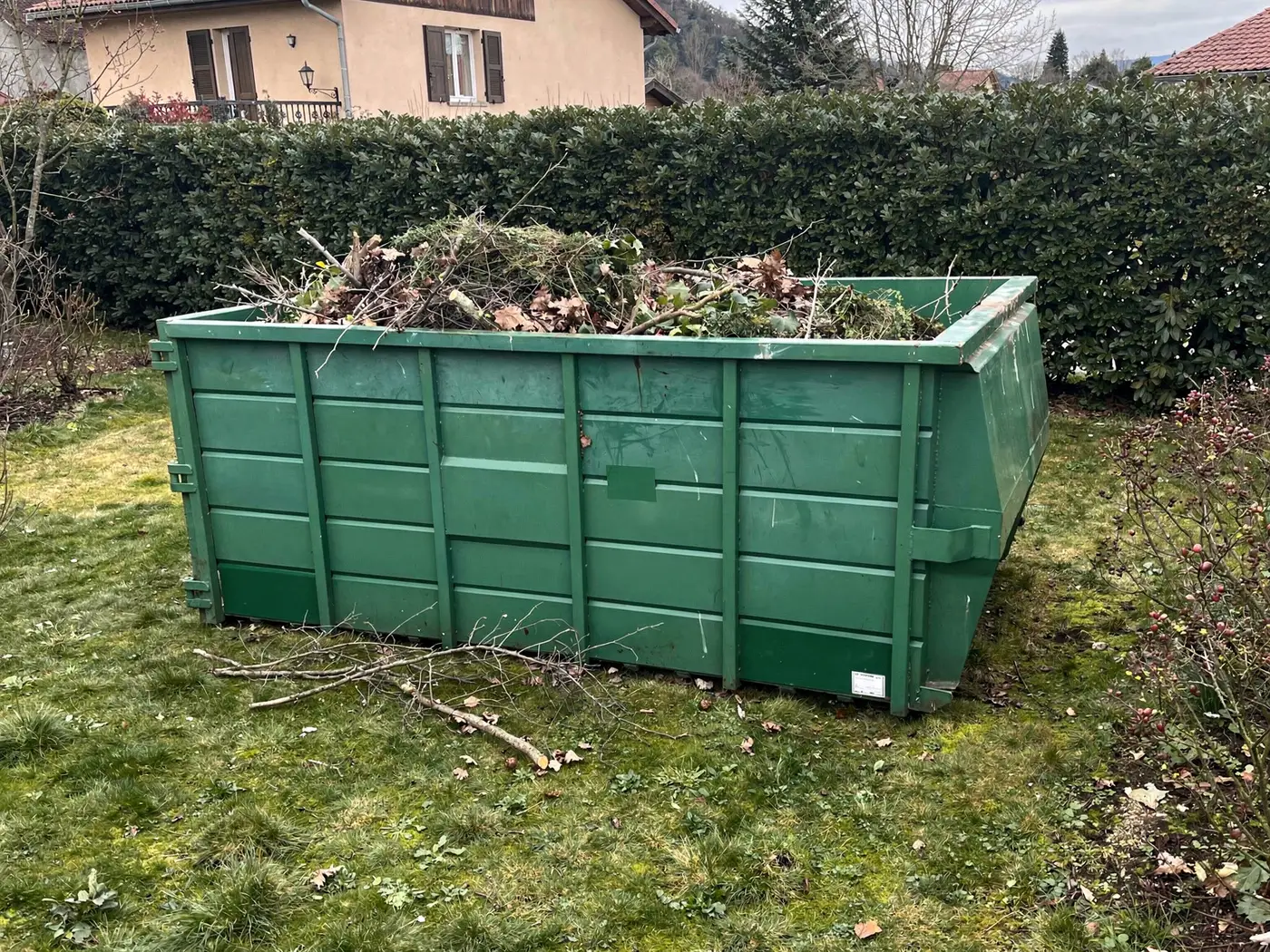Benne remplie de branches dans un jardin près de Grenoble