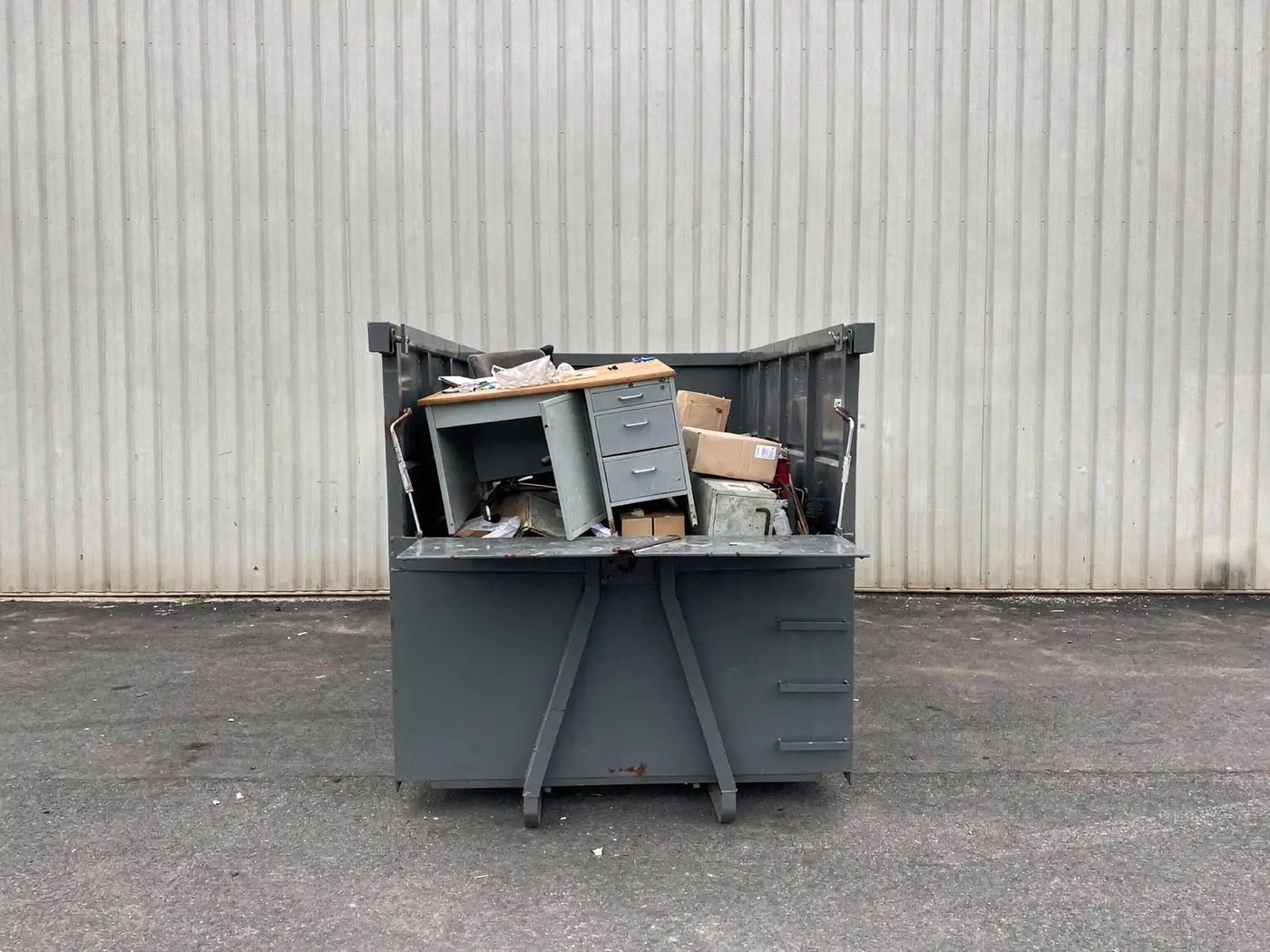 Benne de déchets d'entreprise avec du mobilier de bureau