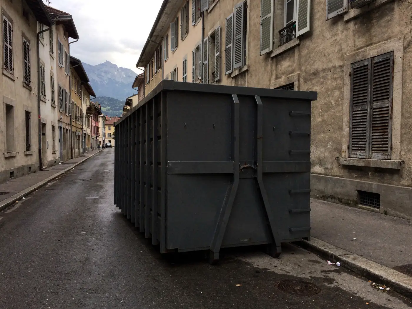 Benne posée le long d'un trottoir dans une rue de Grenoble