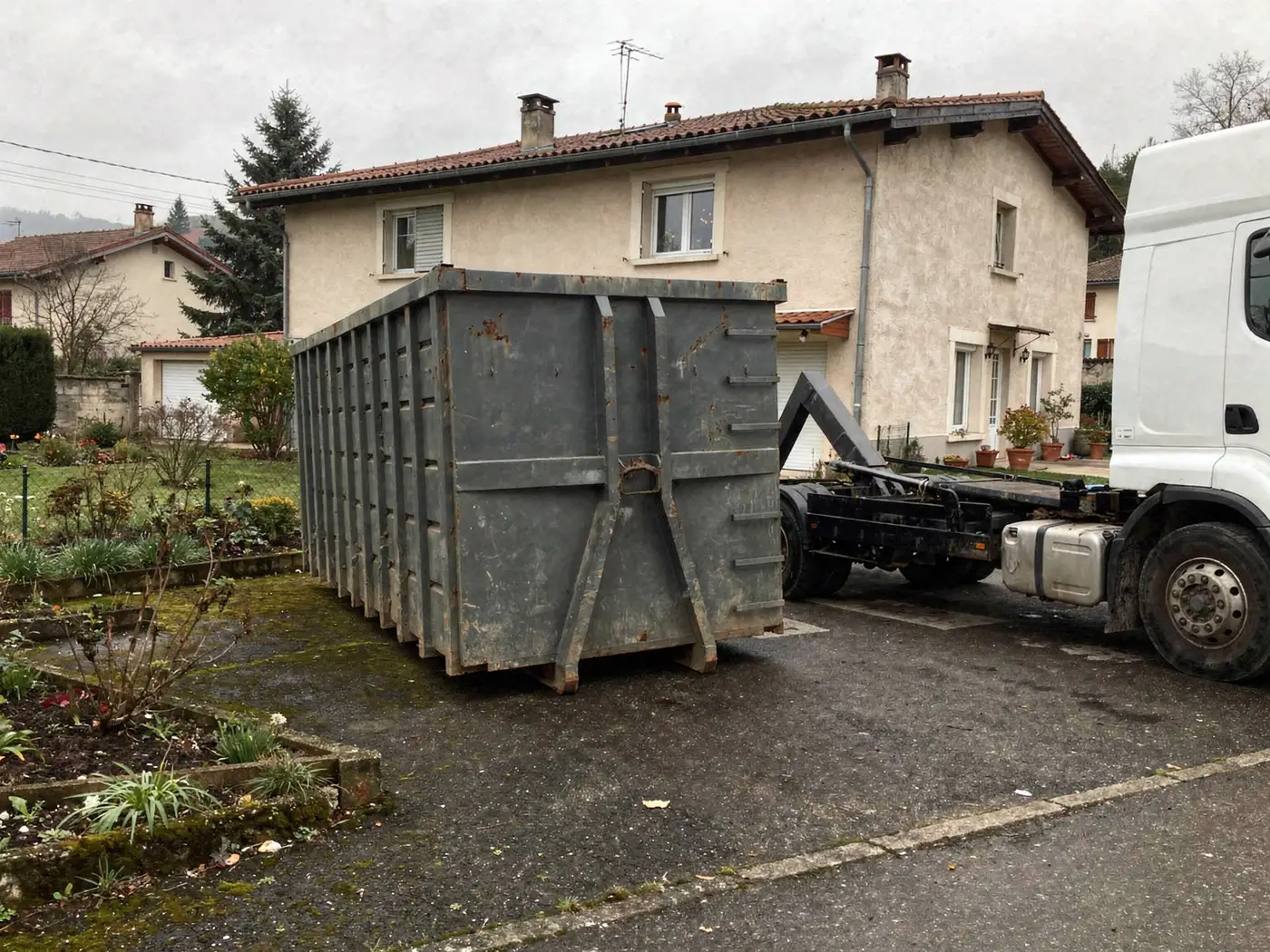Camion à l'arrêt après avoir posé une benne dans une allée près de Voiron